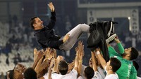 Xavi dilambungkan ke udara oleh para pemainnya. (Foto: AFP/KARIM JAAFAR)