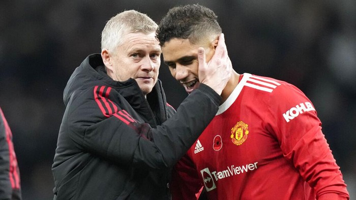 Manchester Uniteds manager Ole Gunnar Solskjaer, left, greets Manchester Uniteds Raphael Varane after the English Premier League soccer match between Tottenham Hotspur and Manchester United at the Tottenham Hotspur Stadium in London, Saturday, Oct. 30, 2021. (AP Photo/Frank Augstein)