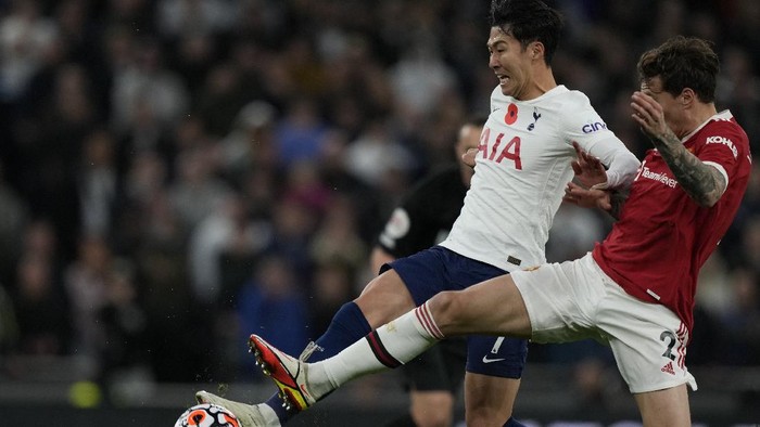 Tottenhams Son Heung-min is challenged by Manchester Uniteds Victor Lindelof, right, during the English Premier League soccer match between Tottenham Hotspur and Manchester United at the Tottenham Hotspur Stadium in London, Saturday, Oct. 30, 2021. (AP Photo/Frank Augstein)