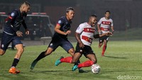 Dua pemain Arema FC berusaha menghentikan serangan yang dilakukan Madura United. Dalam pertandingan ini, Arema FC mampu mencetak gol kemenangan di menit ke-90.