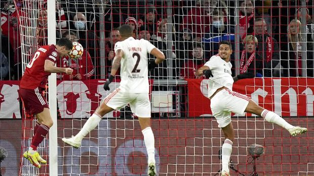 Bayern's Robert Lewandowski, left, heads the ball to score his side's first goal during the Champions League group E soccer match between Bayern Munich and Benfica Lisbon in Munich, Germany, Tuesday, Nov. 2, 2021.(AP Photo/Matthias Schrader)