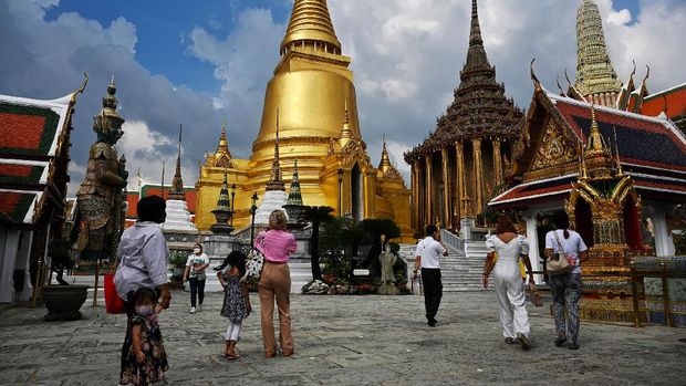 Local visitors enter the Grand Palace on the day of reopening in Bangkok on November 1, 2021, as Thailand welcomes the first groups of tourists fully vaccinated against the Covid-19 coronavirus without quarantine. (Photo by Lillian SUWANRUMPHA / AFP)