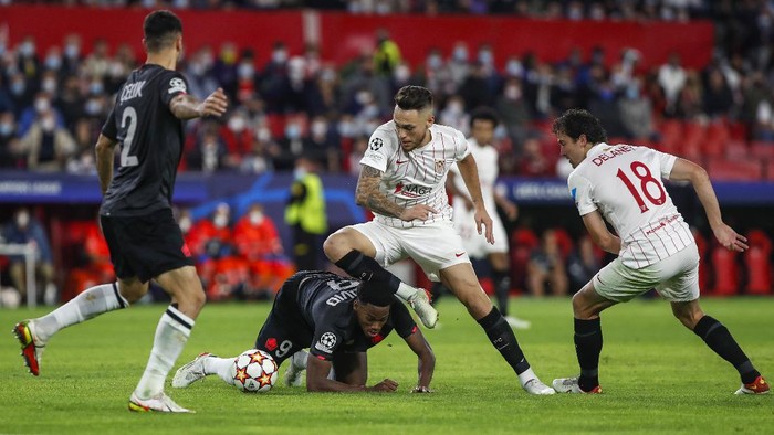 Lilles Jonathan David, second left, vies for the ball with Sevillas Lucas Ocampos, second right, during the Champions League group G soccer match between Sevilla and Lille at the Ramon Sanchez Pizjuan stadium in Seville, Spain, Tuesday, Nov. 2, 2021. (AP Photo/Angel Fernandez)