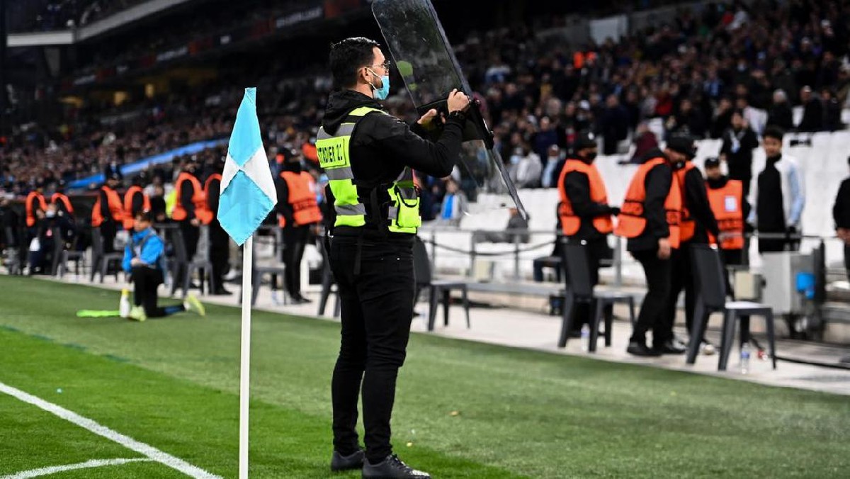Seorang petugas keamanan harus mengeluarkan tamengnya untuk menghindari objek yang dilempar suporter Marseille. Foto: Dok. Sky Sport Italia