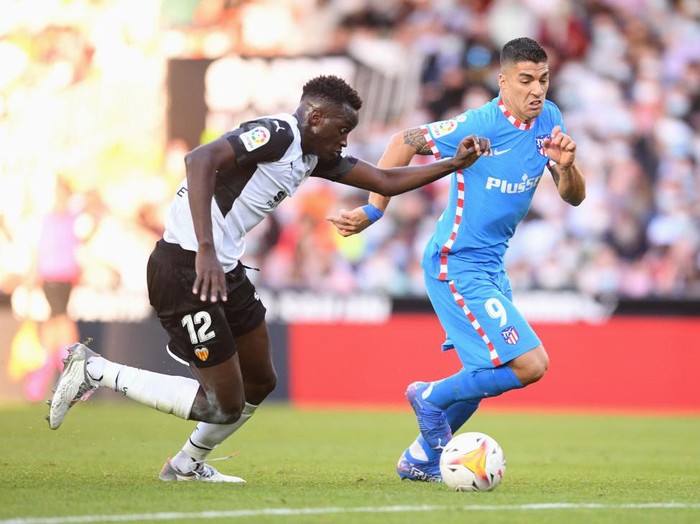 VALENCIA, SPAIN - NOVEMBER 07: Luis Suarez of Atletico Madrid battles for possession with Mouctar Diakhaby of Valencia CF during the La Liga Santander match between Valencia CF and Club Atletico de Madrid at Estadio Mestalla on November 07, 2021 in Valencia, Spain. (Photo by Aitor Alcalde/Getty Images)