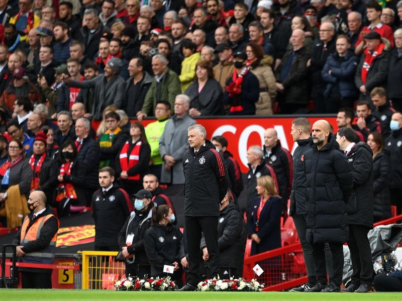 MANCHESTER, ENGLAND - NOVEMBER 06: Ole Gunnar Solskjaer, Manager of Manchester United and Pep Guardiola, Manager of Manchester City observe a minutes silence in respect of the Remembrance Day proceedings prior to the Premier League match between Manchester United and Manchester City at Old Trafford on November 06, 2021 in Manchester, England. (Photo by Michael Regan/Getty Images)