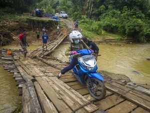 Potret Perjuangan Warga Lintasi Jembatan Darurat di Kalsel