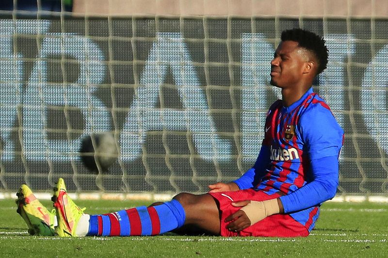 Barcelona's Ansu Fati, sits injured during a Spanish La Liga soccer match between Celta and Barcelona at the Balaidos stadium in Vigo, Spain, Saturday, Nov. 6, 2021. (AP Photo/Lalo R. Villar)