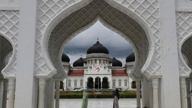 Pengunjung berfoto di kawasan Masjid Raya Baiturrahman, Banda Aceh, Aceh, Rabu (10/11/2021). Masjid Raya Baiturrahman merupakan ikon Provinsi Aceh yang termasuk dalam salah satu masjid tertua dan termegah di Asia yang dibangun abad 16 pada masa Kerajaan Sultan Iskandar Muda yang menjadi objek wisata religi bagi wisatawan domestik dan mancanegara. ANTARA FOTO/Syifa Yulinnas/aww.