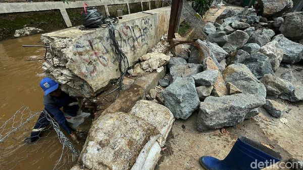 Kerja Keras Pasukan Biru Perbaiki Tanggul Jebol di Kali Baru