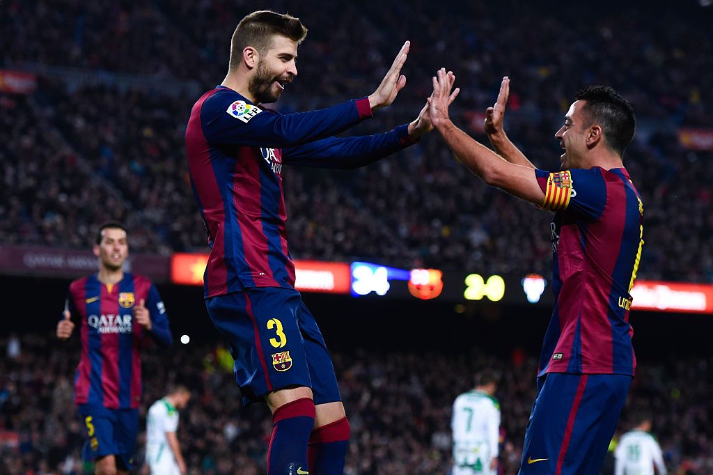 BARCELONA, SPAIN - DECEMBER 20:  Gerard Pique of FC Barcelona celebrates with his teammate Xavi Hernandez of FC Barcelona after scoring his team's third goal during the La Liga match between FC Barcelona and Cordoba CF at Camp Nou on December 20, 2014 in Barcelona, Spain.  (Photo by David Ramos/Getty Images)