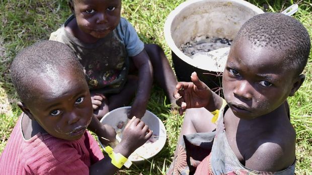 Congolese children share a meal at a temporary camp after fleeing from the renewed fighting between the assailants and army troops of the Democratic Republic of Congo and Uganda, at the Bunagana border crossing point in Western Uganda November 10, 2021. REUTERS/Abubaker Lubowa