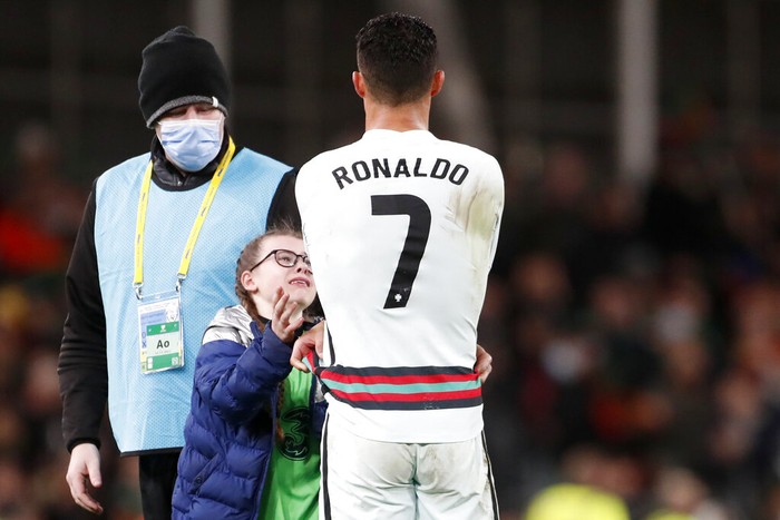 Aksi Manis Ronaldo Kasih Jersey untuk Fans Ciliknya Portugal's Cristiano Ronaldo gives his shirt to a young fan who walked on to the pitch at the end of the World Cup 2022 group A qualifying soccer match between the Republic of Ireland and Portugal at the Aviva stadium in Dublin, Thursday, Nov. 11, 2021. The game ended in a goalless draw. (AP Photo/Peter Morrison)