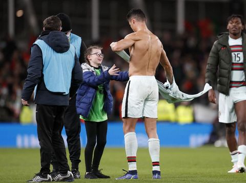 Portugal's Cristiano Ronaldo gives his shirt to a young fan who walked on to the pitch at the end of the World Cup 2022 group A qualifying soccer match between the Republic of Ireland and Portugal at the Aviva stadium in Dublin, Thursday, Nov. 11, 2021. The game ended in a goalless draw. (AP Photo/Peter Morrison)