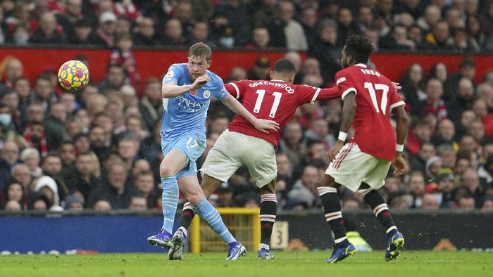 Manchester Citys Kevin De Bruyne, left, dribbles past Manchester Uniteds Mason Greenwood, center, and Manchester Uniteds Fred during the English Premier League soccer match between Manchester United and Manchester City at Old Trafford stadium in Manchester, England, Saturday, Nov. 6, 2021. (AP Photo/Jon Super)