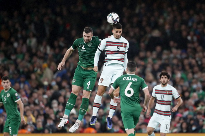 Irelands Shane Duffy, center left, jumps for the ball with Portugals Andre Silva during the World Cup 2022 group A qualifying soccer match between the Republic of Ireland and Portugal at the Aviva stadium in Dublin, Thursday, Nov. 11, 2021. (AP Photo/Peter Morrison)