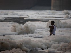 Warga India Rayakan Hari Keagamaan dengan Mandi di Sungai yang Tercemar