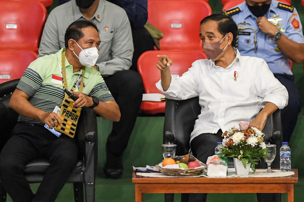 Presiden Joko Widodo (kanan) berbincang dengan Menpora Zainudin Amali (kiri) saat menyaksikan pertandingan final bulu tangkis Peparnas Papua di Gor Cendrawasih, Jayapura, Papua, Sabtu (13/11/2021). Presiden Joko Widodo berkesempatan untuk mengunjungi venue judo dan bulu tangkis sebelum akhirnya menutup Peparnas Papua di Stadion Mandala. ANTARA FOTO/Raisan Al Farisi/nym.