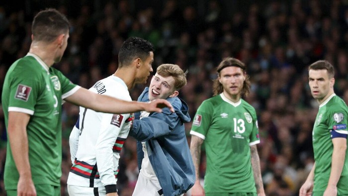 FILE - A pitch invader tries to reach Portugal's Cristiano Ronaldo, 2nd left, during the World Cup 2022 group A qualifying soccer match between the Republic of Ireland and Portugal at the Aviva stadium in Dublin, Thursday, Nov. 11, 2021. (AP Photo/Peter Morrison, File)