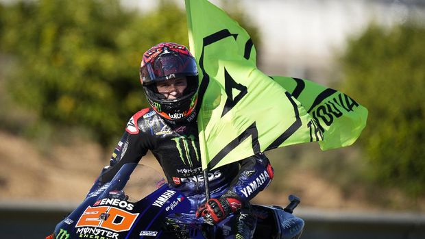 Fabio Quartararo membawa bendera VR46 Valentino Rossi usai MotoGP Valencia 2021.