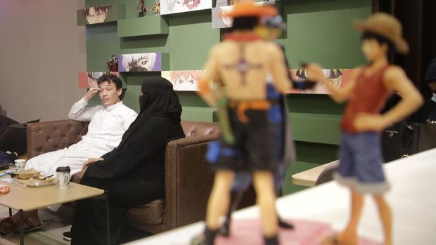Saudi Abdel Rahim Jassim, sets with his wife at Geek Cafe, one of the newest in a growing list of Japan-inspired eateries, in Jiddah, Saudi Arabia, late Thursday, Nov. 11, 2021. (AP Photo/Amr Nabil)