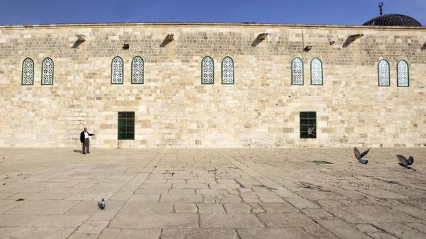 A man stands by a wall of Al-Aqsa Mosque, decorated with stained-glass windows, on the compound known to Muslims as Noble Sanctuary and to Jews as Temple Mount, in Jerusalem's Old City November 16, 2021. Picture taken November 16, 2021. REUTERS/Ammar Awad