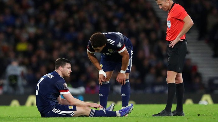 GLASGOW, SCOTLAND - NOVEMBER 15: Andy Robertson of Scotland reacts as he looks to be injured during the 2022 FIFA World Cup Qualifier match between Scotland and Denmark at Hampden Park on November 15, 2021 in Glasgow, Scotland. (Photo by Ian MacNicol/Getty Images)