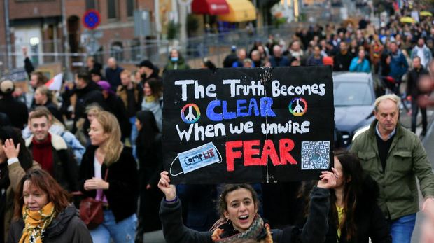 A person holds a sign during demonstrations against coronavirus disease (COVID-19) measures in Amsterdam, Netherlands, November 20, 2021. REUTERS/Eva Plevier
