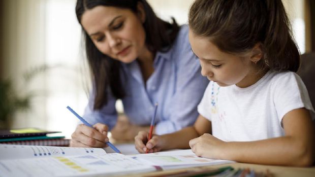 Mother helping daughter with homework