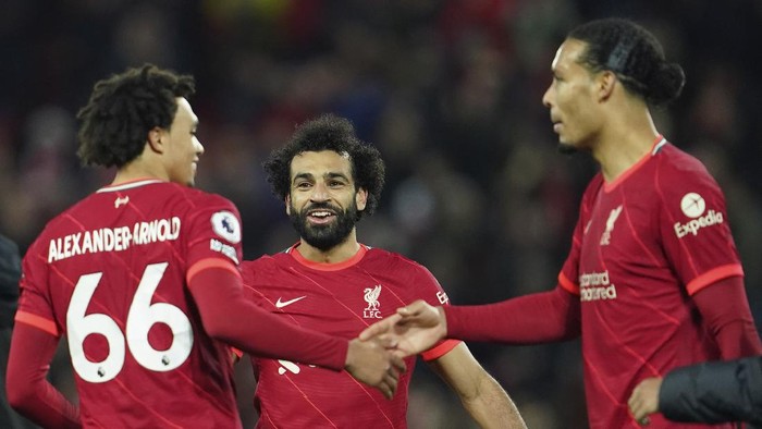 Liverpools Trent Alexander-Arnold, left, Liverpools Mohamed Salah, centre, Liverpools Virgil van Dijk celebrate at the end of the English Premier League soccer match between Liverpool and Arsenal at Anfield Stadium, Liverpool, England, Saturday, Nov. 20, 2021. (AP Photo/Jon Super)