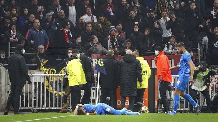 Marseilles Dimitri Payet reacts after being injured by an object thrown by a Lyons supporter during the French League One soccer match between Lyon and Marseille, in Decines, near Lyon, central France, Sunday, Nov. 21, 2021. (AP Photo/Laurent Cipriani)