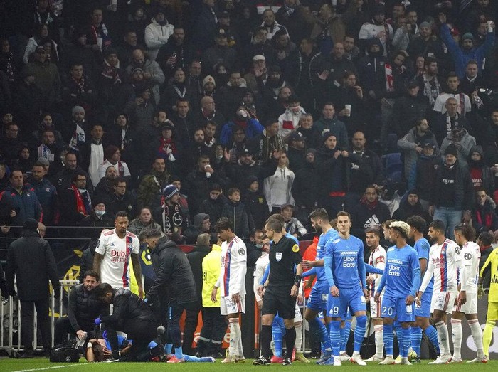 Marseille's medical staff take care of Dimitri Payet after he was injured by an object thrown by a Lyon's supporter during the French League One soccer match between Lyon and Marseille, in Decines, near Lyon, central France, Sunday, Nov. 21, 2021. (AP Photo/Laurent Cipriani)