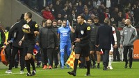 Payet terlihat memegangi kepalanya yang terkena lemparan botol. (Foto: AP/Laurent Cipriani)