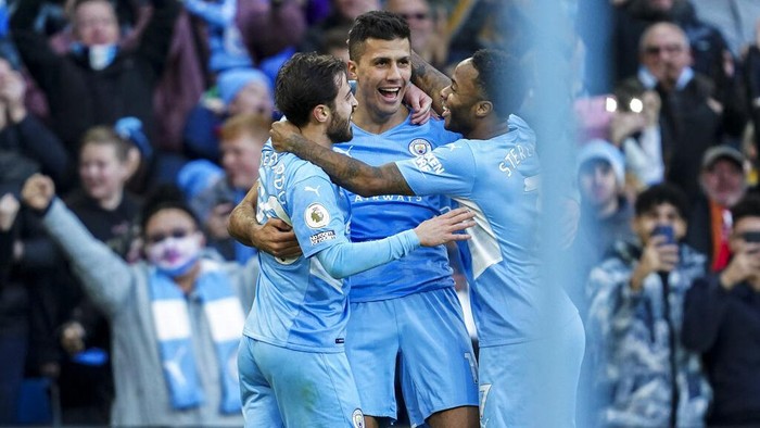 Manchester Citys Rodrigo, center, is congratulated by teammates Bernardo Silva and Raheem Sterling, right, after scoring his team second goal during the English Premier League soccer match between Manchester City and Everton at Etihad stadium in Manchester, England, Sunday, Nov. 21, 2021. (AP Photo/Jon Super)