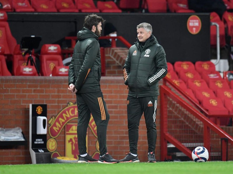 MANCHESTER, ENGLAND - MARCH 14: Ole Gunnar Solskjaer (R), Manager of Manchester United speaks with Michael Carrick, First Team Coach of Manchester United during the Premier League match between Manchester United and West Ham United at Old Trafford on March 14, 2021 in Manchester, England. Sporting stadiums around the UK remain under strict restrictions due to the Coronavirus Pandemic as Government social distancing laws prohibit fans inside venues resulting in games being played behind closed doors. (Photo by Peter Powell - Pool/Getty Images)