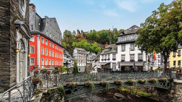 Bridge over the Rur river with traditional buildings in the city center of Monschau, a beautiful resort town in the Eifel region of Germany.