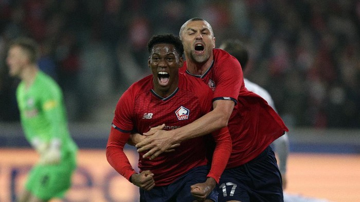 Lilles scorer Jonathan David, left, celebrates with teammate Burak Yilmaz, right, after scoring the opening goal during the Champions League group G soccer match between OSC Lille and RB Salzburg at the Stade Pierre Mauroy - Villeneuve dAscq in Lille, France, Tuesday, Nov. 23, 2021. (AP Photo/Michel Spingler)