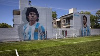 Mural bintang sepak bola Diego Maradona, kiri, dan Lionel Messi, kanan, menghiasi lapangan sepak bola pribadi Giuseppe Meazza di Buenos Aires, Argentina. (AP/Rodrigo Abd)