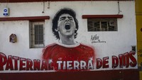 Lukisan dinding mendiang bintang sepak bola Diego Maradona menutupi dinding dekat stadion Argentinos Juniors di Buenos Aires, Argentina. (AP/Rodrigo Abd)