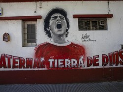 Lukisan dinding mendiang bintang sepak bola Diego Maradona menutupi dinding dekat stadion Argentinos Juniors di Buenos Aires, Argentina. (AP/Rodrigo Abd)