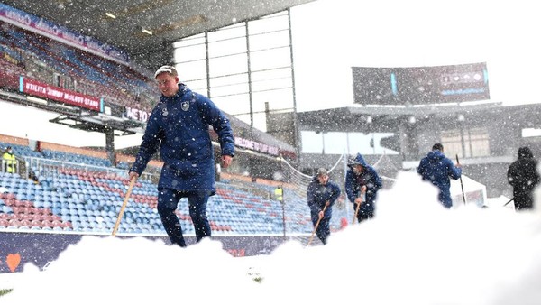 BURNLEY, ENGLAND - NOVEMBER 28: A general view inside the stadium as groundsman attempt to clear snow from the pitch prior to the Premier League match between Burnley and Tottenham Hotspur at Turf Moor on November 28, 2021 in Burnley, England. (Photo by Jan Kruger/Getty Images)