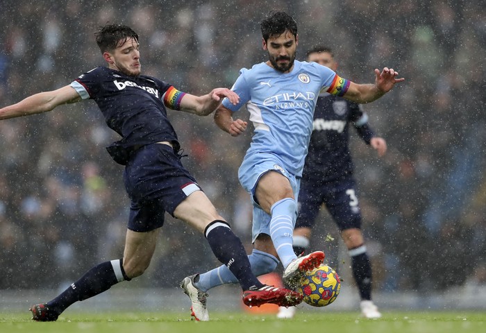 West Hams Declan Rice, left, duels for the ball with Manchester Citys Ilkay Gundogan during the English Premier League soccer match between Manchester City and West Ham United at the Etihad stadium in Manchester, England, Sunday, Nov. 28, 2021. (AP Photo/Scott Heppell)