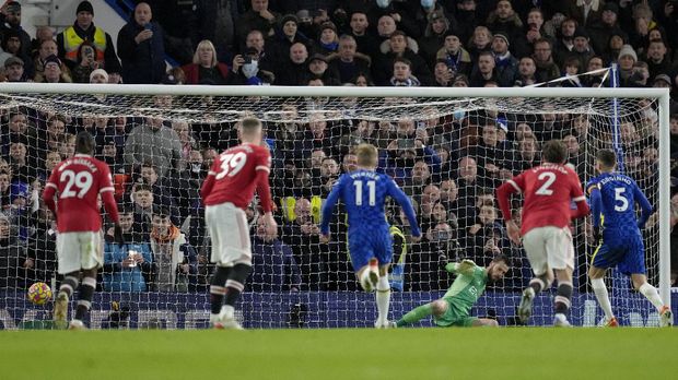 Chelsea's Jorginho, right, scores his side's first goal from the penalty spot during the English Premier League soccer match between Chelsea and Manchester United at Stamford Bridge stadium in London, Sunday, Nov. 28, 2021. (AP Photo/Kirsty Wigglesworth)