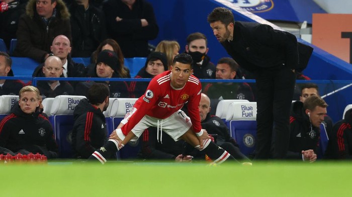 Cristiano Ronaldo, Chelsea vs MU LONDON, ENGLAND - NOVEMBER 28: Cristiano Ronaldo of Manchester United takes instructions from Michael Carrick, Interim Manager of Manchester United as he prepares to come on as a substitute during the Premier League match between Chelsea and Manchester United at Stamford Bridge on November 28, 2021 in London, England. (Photo by Clive Rose/Getty Images)