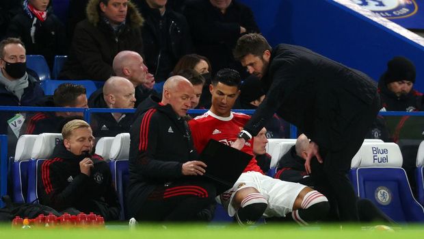 LONDON, ENGLAND - NOVEMBER 28: Cristiano Ronaldo of Manchester United takes instructions from Michael Carrick, Interim Manager of Manchester United as he prepares to come on as a substitute during the Premier League match between Chelsea and Manchester United at Stamford Bridge on November 28, 2021 in London, England. (Photo by Clive Rose/Getty Images)