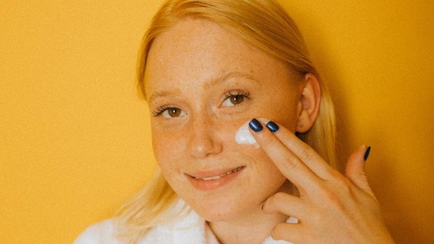 Ilustrasi perempuan menggunakan moisturizer cream