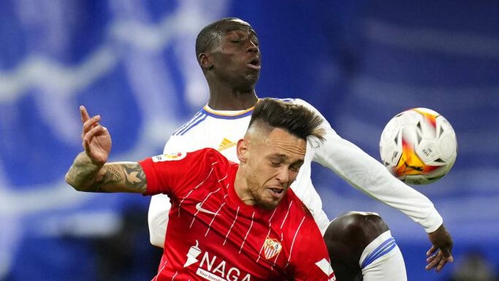 Sevillas Lucas Ocampos, foreground, fights for the ball with Real Madrids Ferland Mendy, background, during the Spanish La Liga soccer match between Real Madrid and Sevilla at the Bernabeu stadium in Madrid, Spain, Sunday, Nov. 28, 2021. (AP Photo/Manu Fernandez)