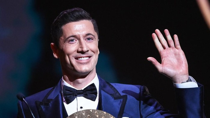 Bayern Munichs Polish forward Robert Lewandowski waves on stage after being awarded the Striker of the Year award  the 2021 Ballon dOr France Football award ceremony at the Theatre du Chatelet in Paris on November 29, 2021. (Photo by FRANCK FIFE / AFP)
