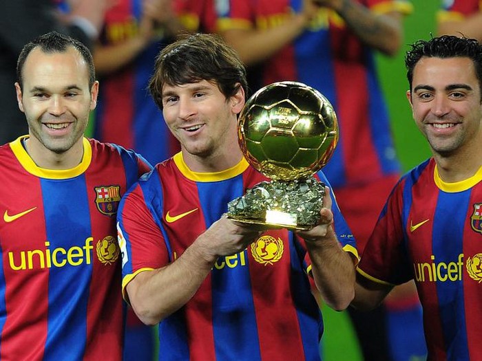 Barcelona's Argentinian forward Lionel Messi (C), flanked with Barcelona's midfielder Xavi Hernandez (R) and Barcelona's midfielder Andres Iniesta (L), poses with the 2010 Ballon d'Or trophy (Golden Ball) for the best European footballer of the year prior to the Copa del Rey (King's Cup) football match FC Barcelona vs Real Betis on January 12, 2011 at the Camp Nou stadium in Barcelona. AFP PHOTO/ LLUIS GENE (Photo by LLUIS GENE / AFP)