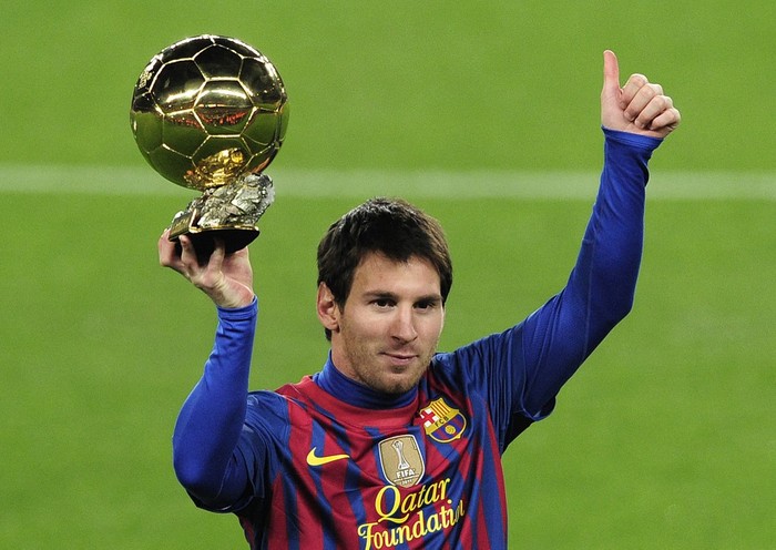 Barcelona's Argentinian forward Lionel Messi poses with the 2011 Ballon d'Or on January 15, 2012 before the Spanish Cup football match opposing FC Barcelona to Real Betis at the Camp Nou stadium in Barcelona. AFP PHOTO/ JOSEP LAGO (Photo by JOSEP LAGO / AFP)
